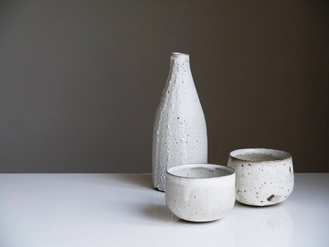 Minimal arrangement of a white ceramic bottle and two cups